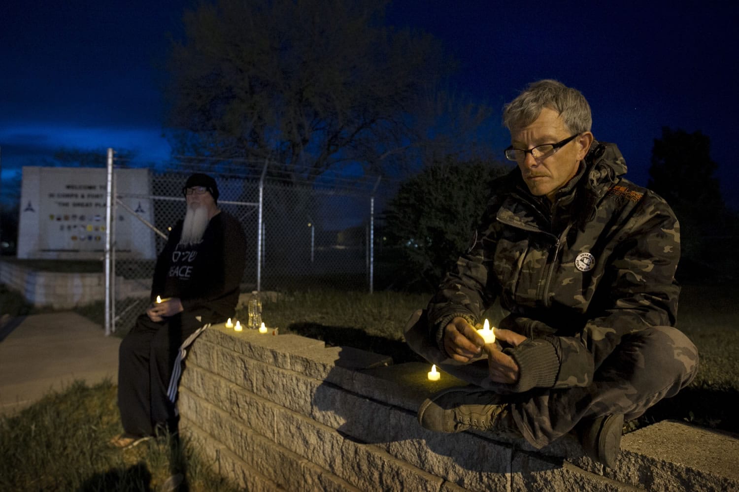 Army veterans David Bass, left, Michael Clift participate in a candlelight vigil for the victims of Wednesday's shooting at Fort Hood, at the East Gate of the Texas military base, on Friday, April 4, 2014. The Fort Hood soldier who gunned down three other military men before killing himself had an argument with colleagues in his unit before opening fire, and investigators believe his mental condition was not the &quot;direct precipitating factor&quot; in the shooting, authorities said Friday.