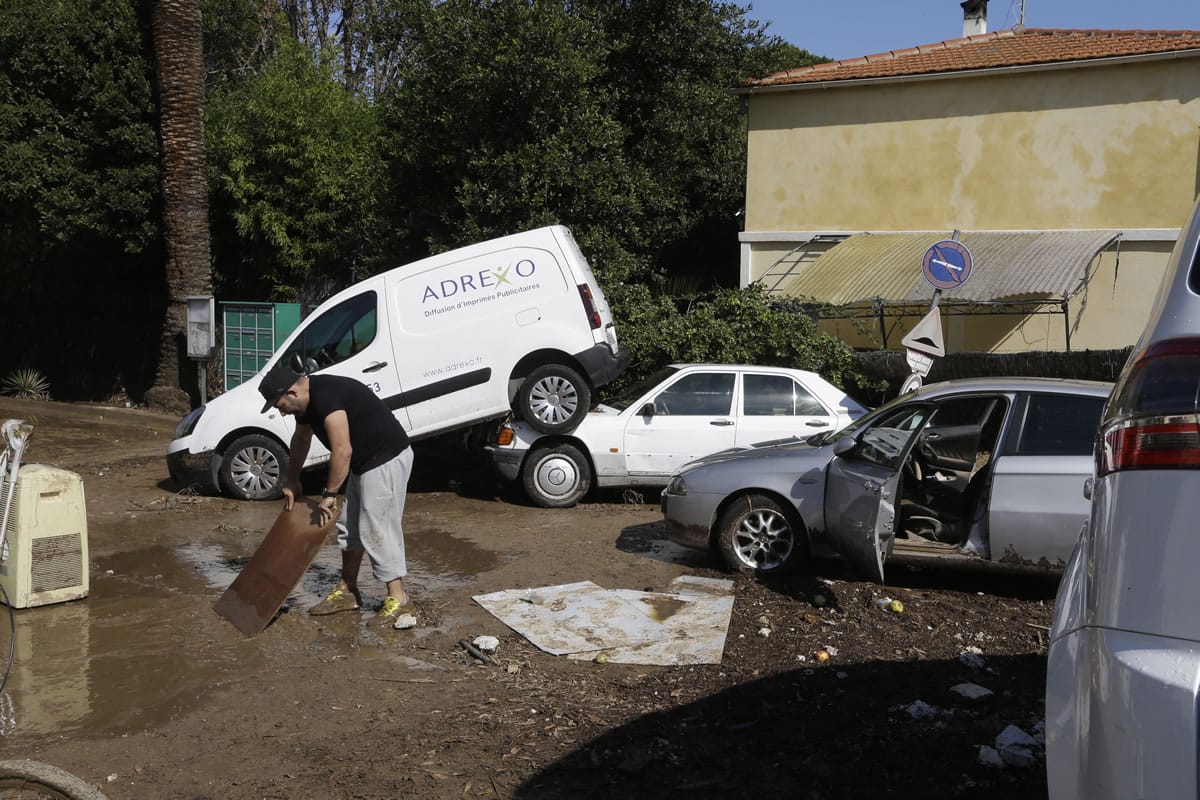 A man washes items in a street of Golf Juan, southern France, Sunday. Flash flooding around the French Riviera has killed more than a dozen of people, including some trapped in cars, a campsite and a retirement home. Torrents of muddy water also inundated buildings, roads and railway tracks, disrupting car and train traffic along the Mediterranean coast.