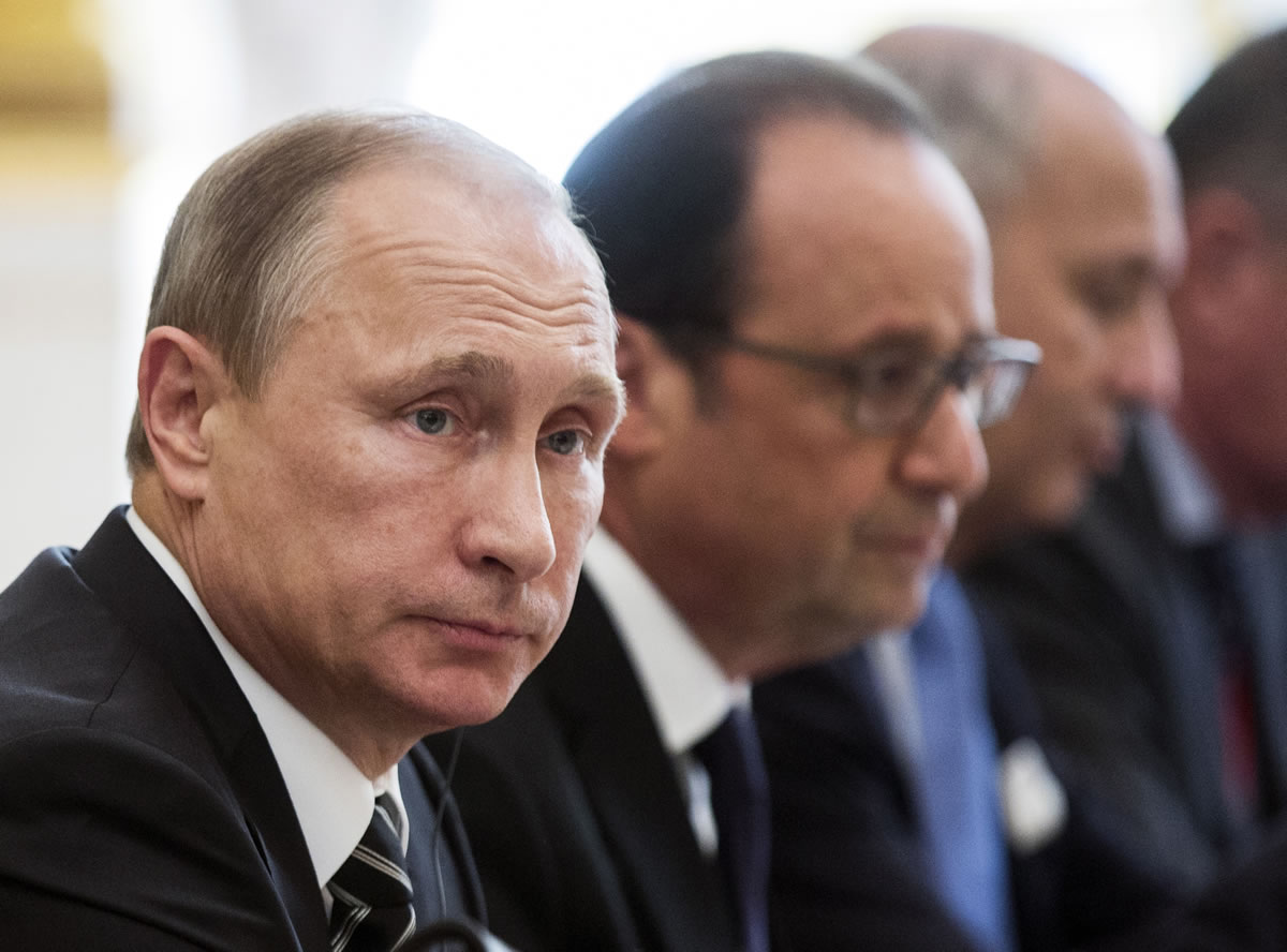 Russian President Vladimir Putin, left, and French President Francois Hollande, center, attend a meeting with German Chancellor Angela Merkel and Ukrainian President Petro Poroshenkoat the Elysee Palace in Paris, France, on Friday, in a revived European push to bring peace to eastern Ukraine. The long-awaited summit in Paris on Friday is being overshadowed by international concerns about Russia&#039;s military intervention in Syria this week.