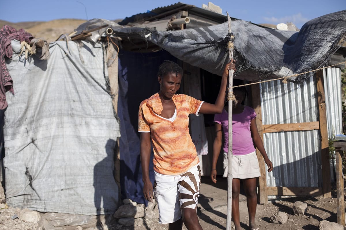 Rosena Dordor, 40, stands in front of her one-room shack Friday in the arid hills north of Port-au-Prince, Haiti.