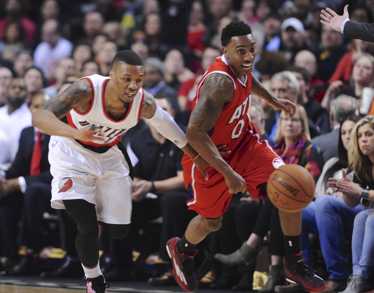 Atlanta's Jeff Teague, right, and Portland's Damian Lillard give chase to the ball during the first half Saturday.