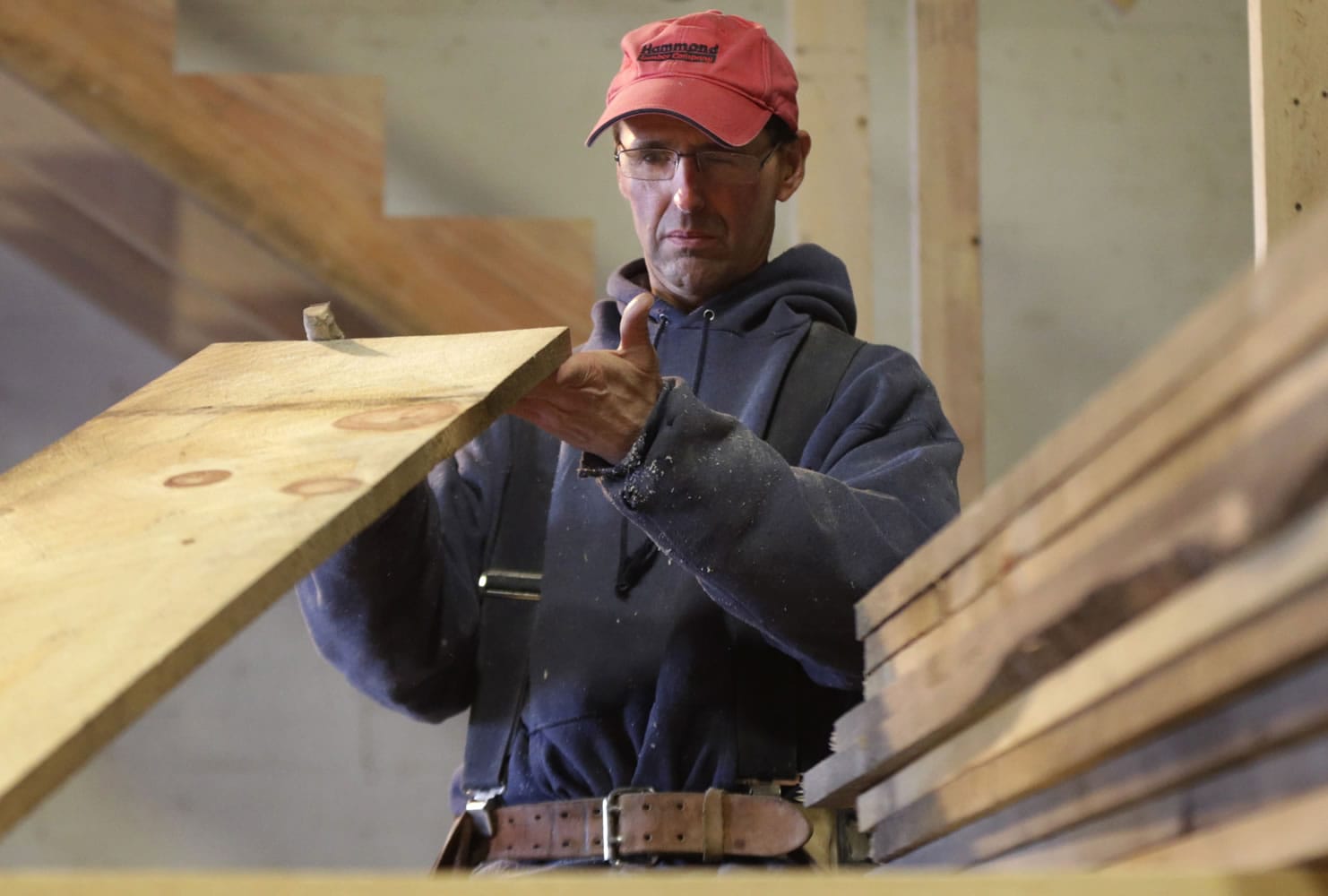 Ken Voorhees examines a board for defects while building a stairway for a customer in Lisbon, Maine. Voorhees, who is self-employed, signed up for health insurance with Maine Health Community Options.