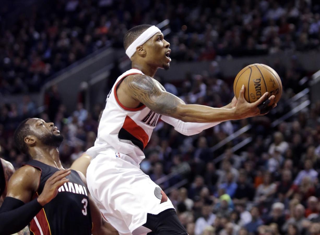 Portland's Damian Lillard, right, drives to the basket past Miami's Dwyane Wade during the second half Thursday.