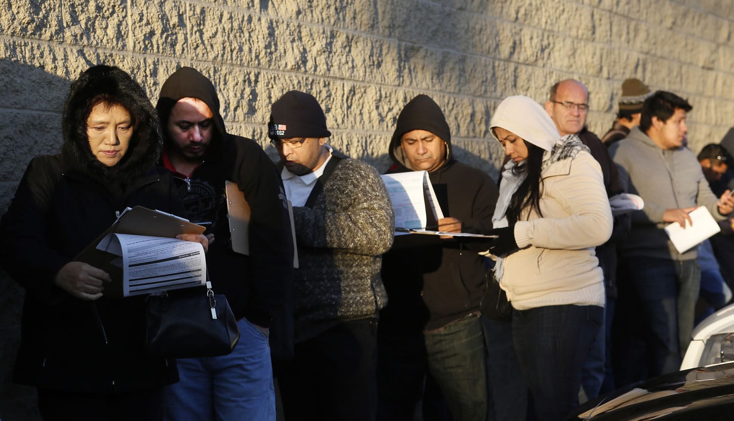Immigrants line up Friday after spending the night outside a California Department of Motor Vehicles office in Stanton, Calif.