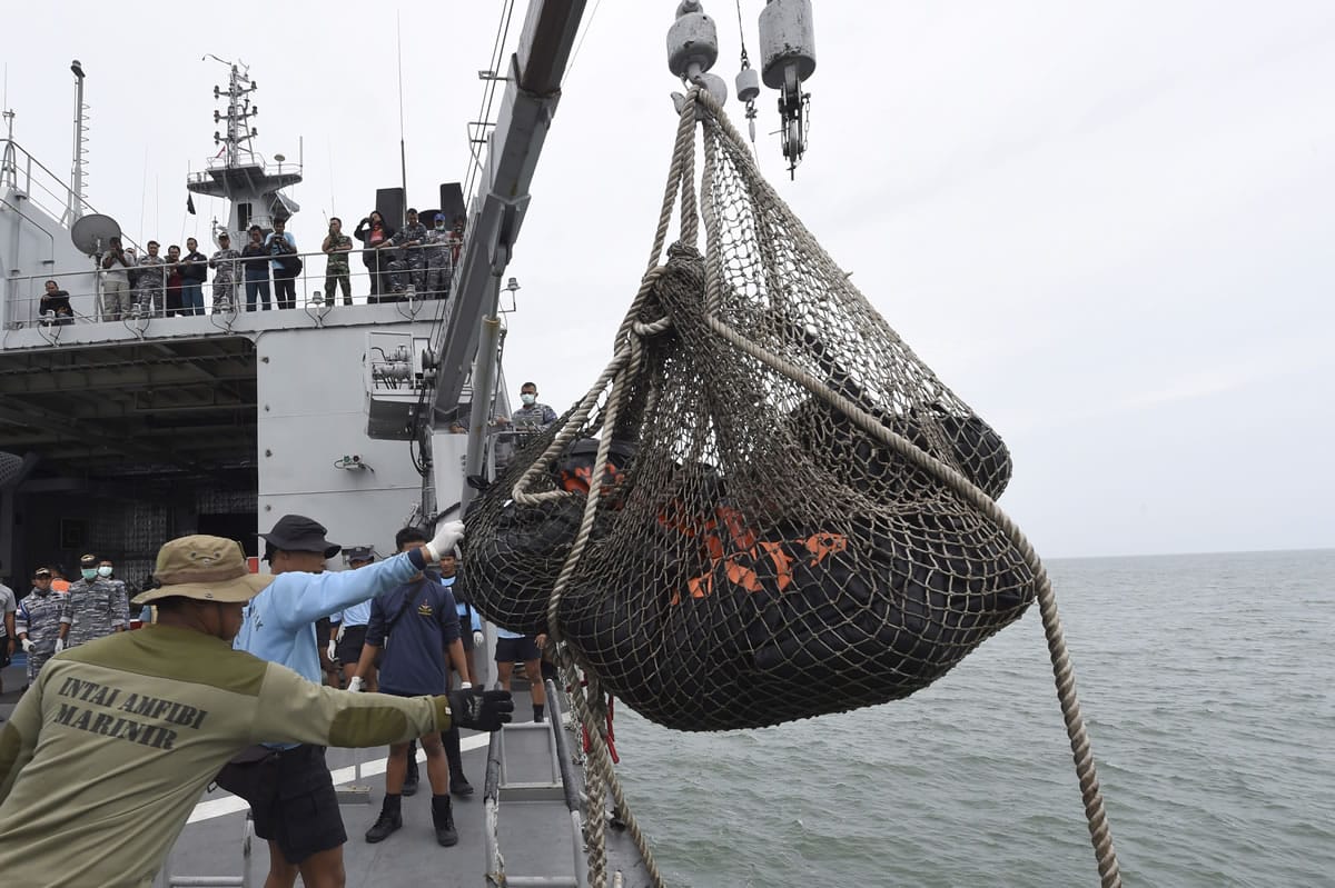 Dead bodies of victims of AirAsia Flight 8501 are lifted to Indonesian navy vessel KRI Banda Aceh at sea off the coast of Pangkalan Bun, Indonesia, Saturday, Jan. 3, 2015. Indonesian officials were hopeful Saturday they were honing in on the wreckage of the flight after sonar equipment detected two large objects on the ocean floor, a full week after the plane went down in stormy weather.