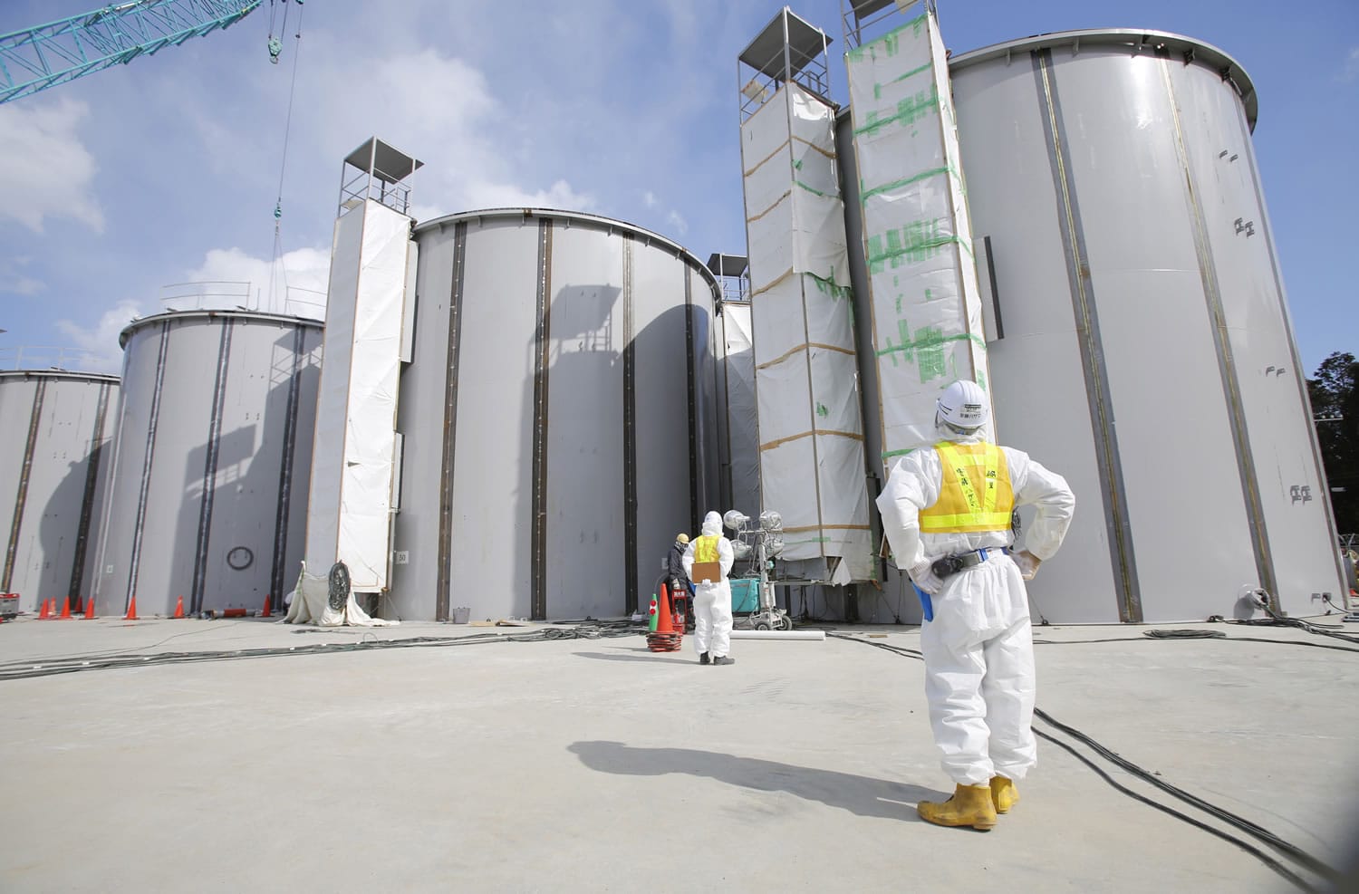 A worker in a protective suit and a mask looks at tanks, under construction, to store radioactive water, in the J1 area at Tokyo Electric Power Co's tsunami-crippled Fukushima Daiichi nuclear power plant in northeastern Japan.