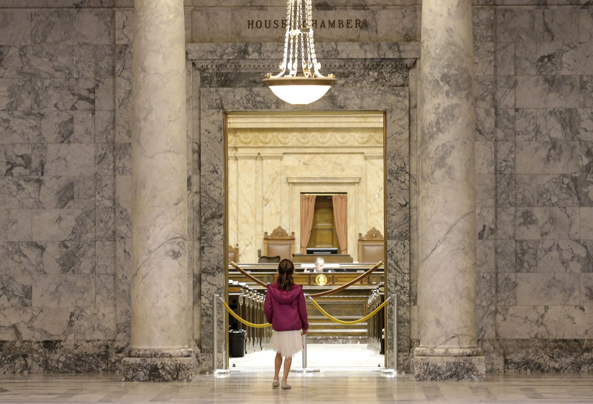 Aizza Benitez, 8, looks in on the nearly empty House Chambers Thursday during a visit to the Capitol in Olympia.