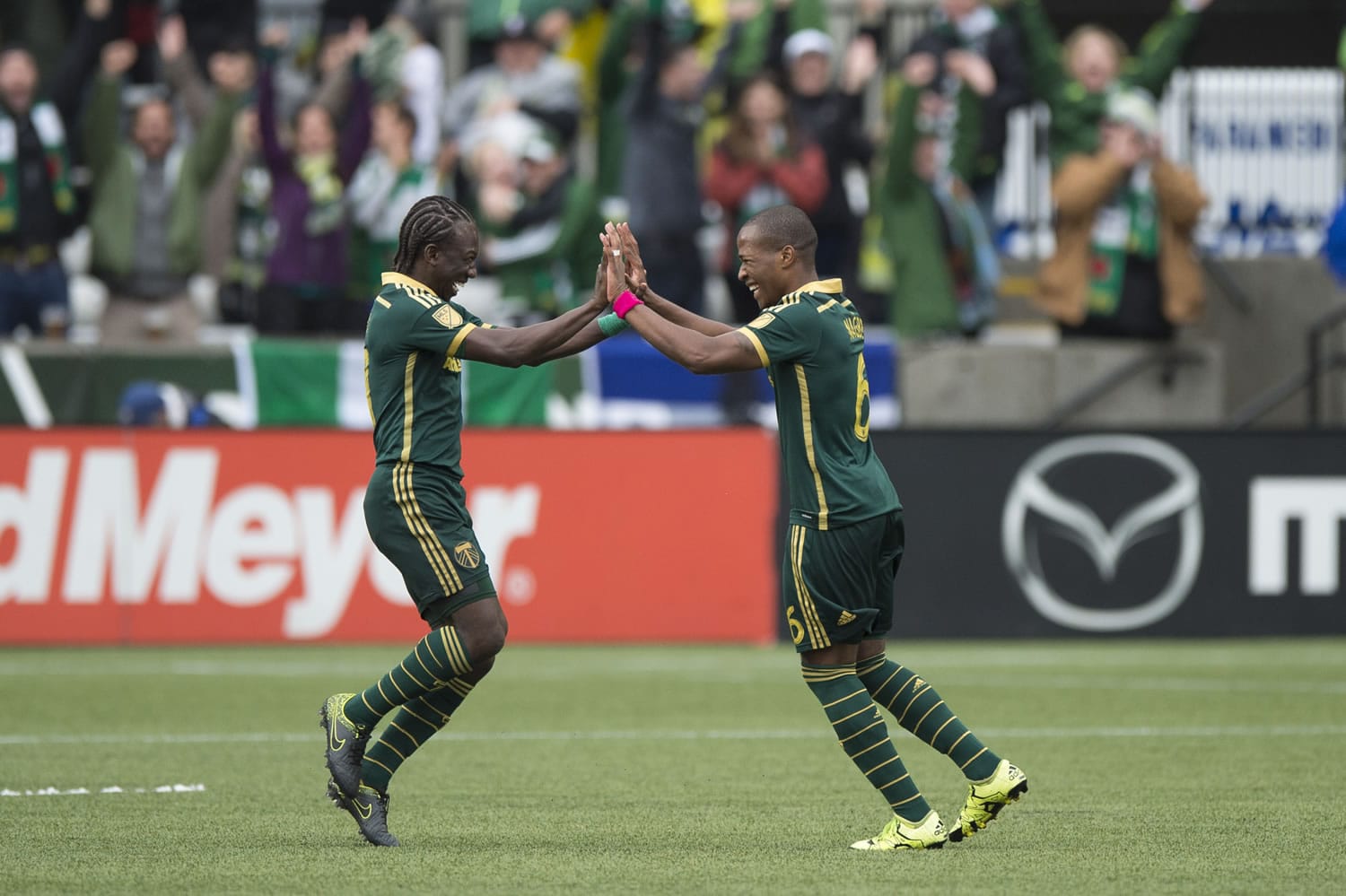 Portland Timbers midfielder Diego Chara, left, celebrates with teammate Darlington Nagbe, right, after Nagbe scored a goal in a game against the Colorado Rapids during the first half of their MLS soccer game in Portland, Ore., Sunday, Oct. 25, 2015.