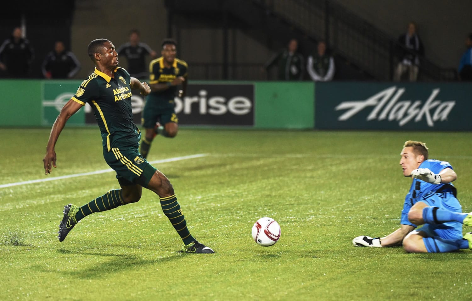 Sporting KC goalkeeper Tim Melia (29) goes after a ball as Portland Timbers forward Fanendo Adi (9) closes in during the first half of a knockout round MLS playoff soccer match in Portland, Ore. on Thursday, Oct. 29, 2015.