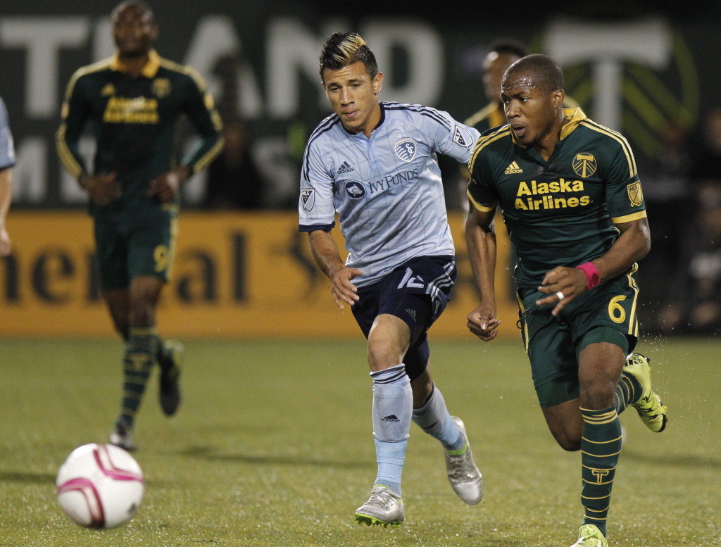 Portland Timbers forward/midfielder Darlington Nagbe, right, brings ball up field against Sporting KC midfielder Mikey Lopez, left, during the first half of an MLS soccer match in Portland, Ore., Saturday, Oct. 3, 2015.