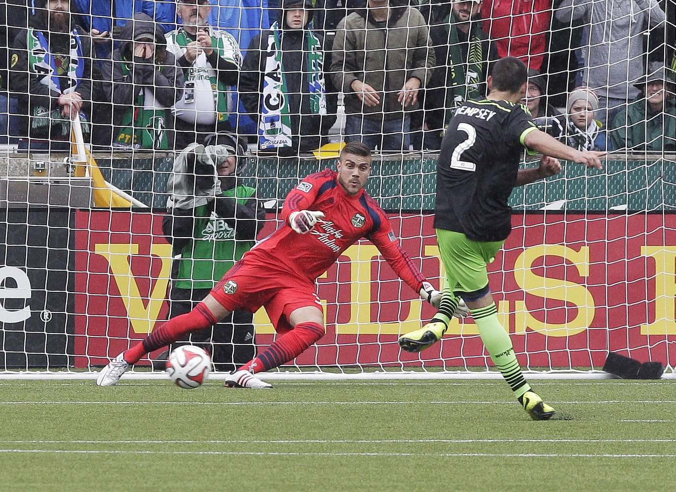 Seattle Sounders midfielder Clint Dempsey, right, scores on a penalty kick to tie the game against Portland Timbers goalkeeper Andrew Weber late in the second half of an MLS soccer game in Portland, Ore., Saturday, April 5, 2014. The two teams tied 4-4.