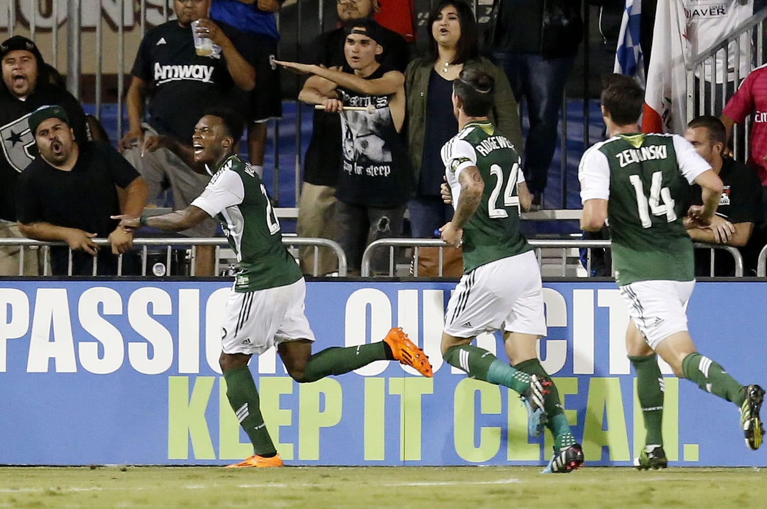 Portland Timbers' Rodney Wallace, left, celebrates with teammates Ben Zemanski (14) and Liam Ridgewell (24) after scoring a goal against the San Jose Earthquakes during the second half in Santa Clara, Calif., Saturday, Oct. 4, 2014. Portland won 2-1.
