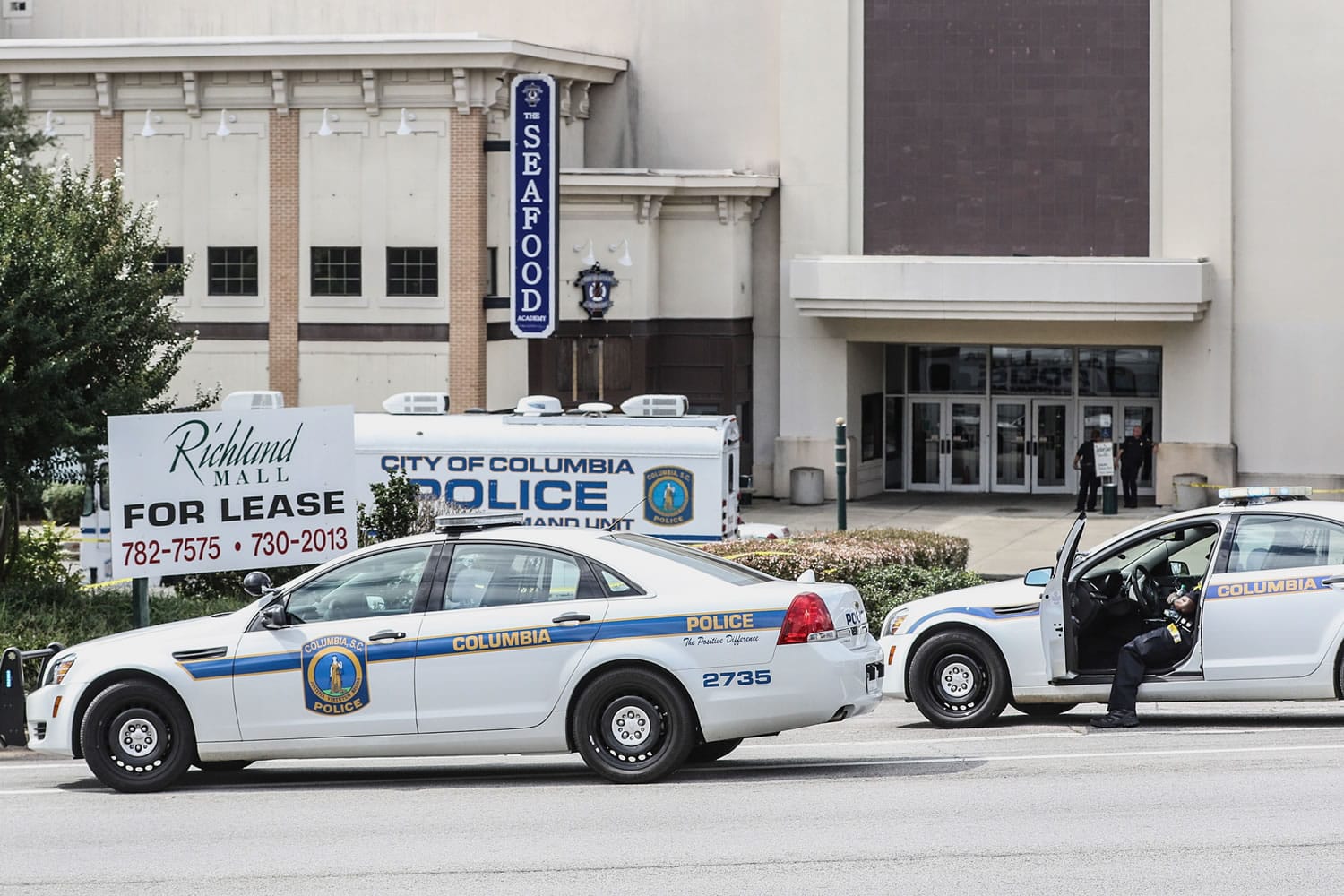 Columbia Police Officers investigate the scene where a Forest Acres Police Officer was fatally shot in the Richland Mall on Wednesday in Forest Acres, S.C. Police say a suspect is in custody.