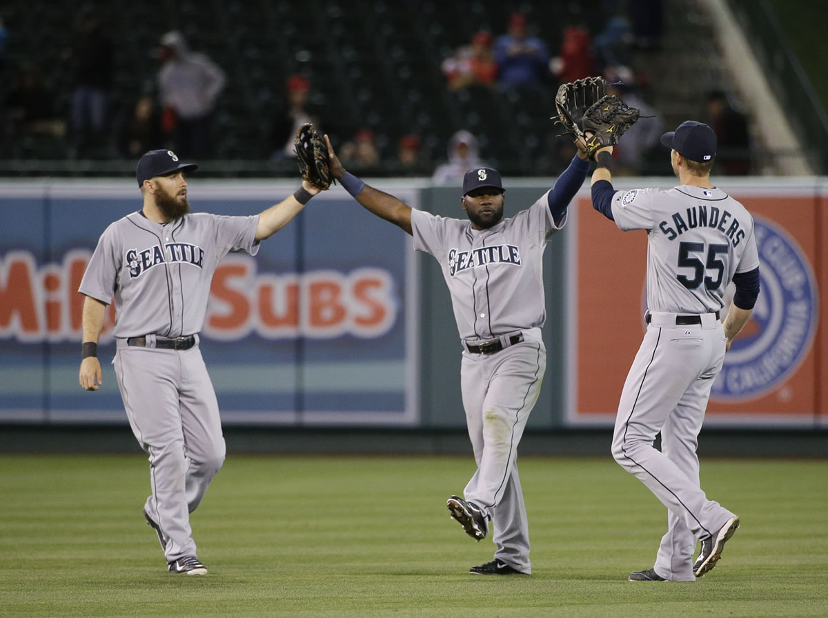 Seattle Mariners' Dustin Ackley, Abraham Almonte and Michael Saunders, from left, celebrate their team's 8-2 win against the Los Angeles Angels.