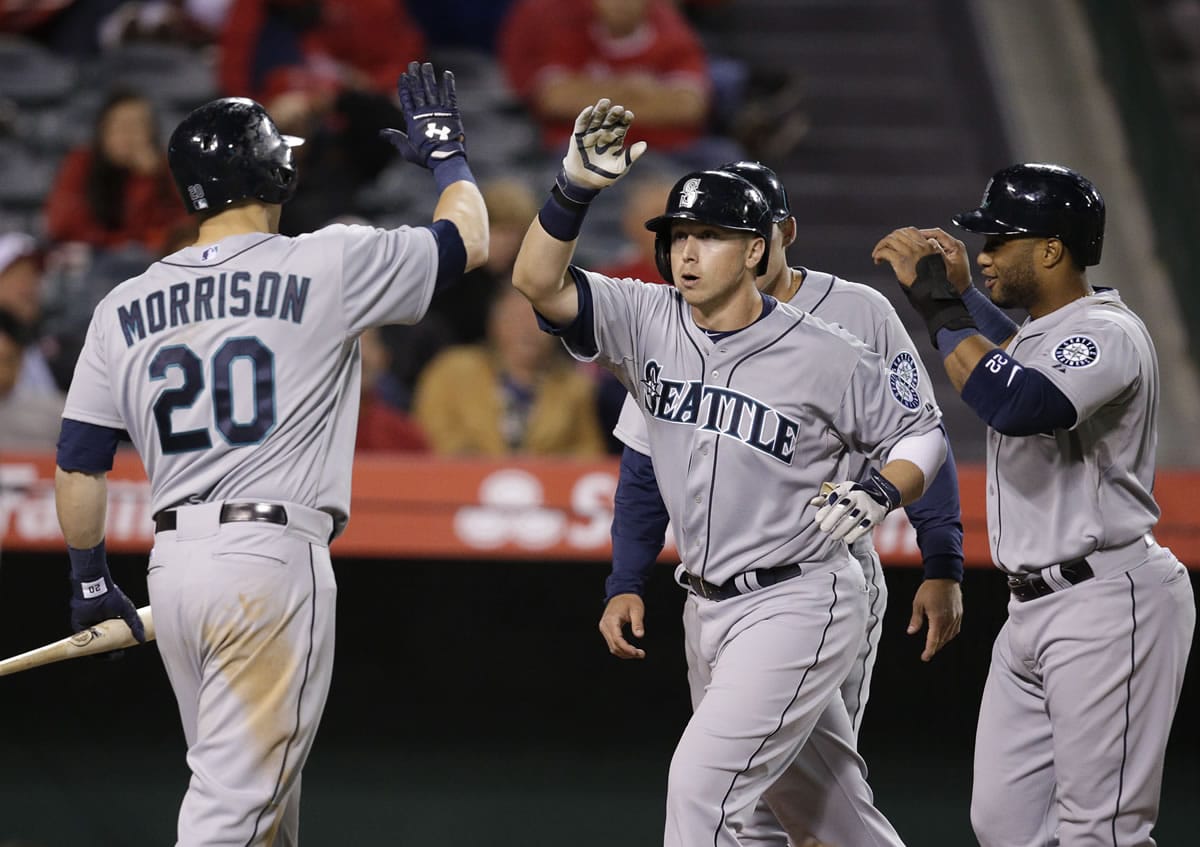 Seattle's Justin Smoak, center, celebrates his three-run home run with Logan Morrison, left, and Robinson Cano, right, during the ninth inning Monday.