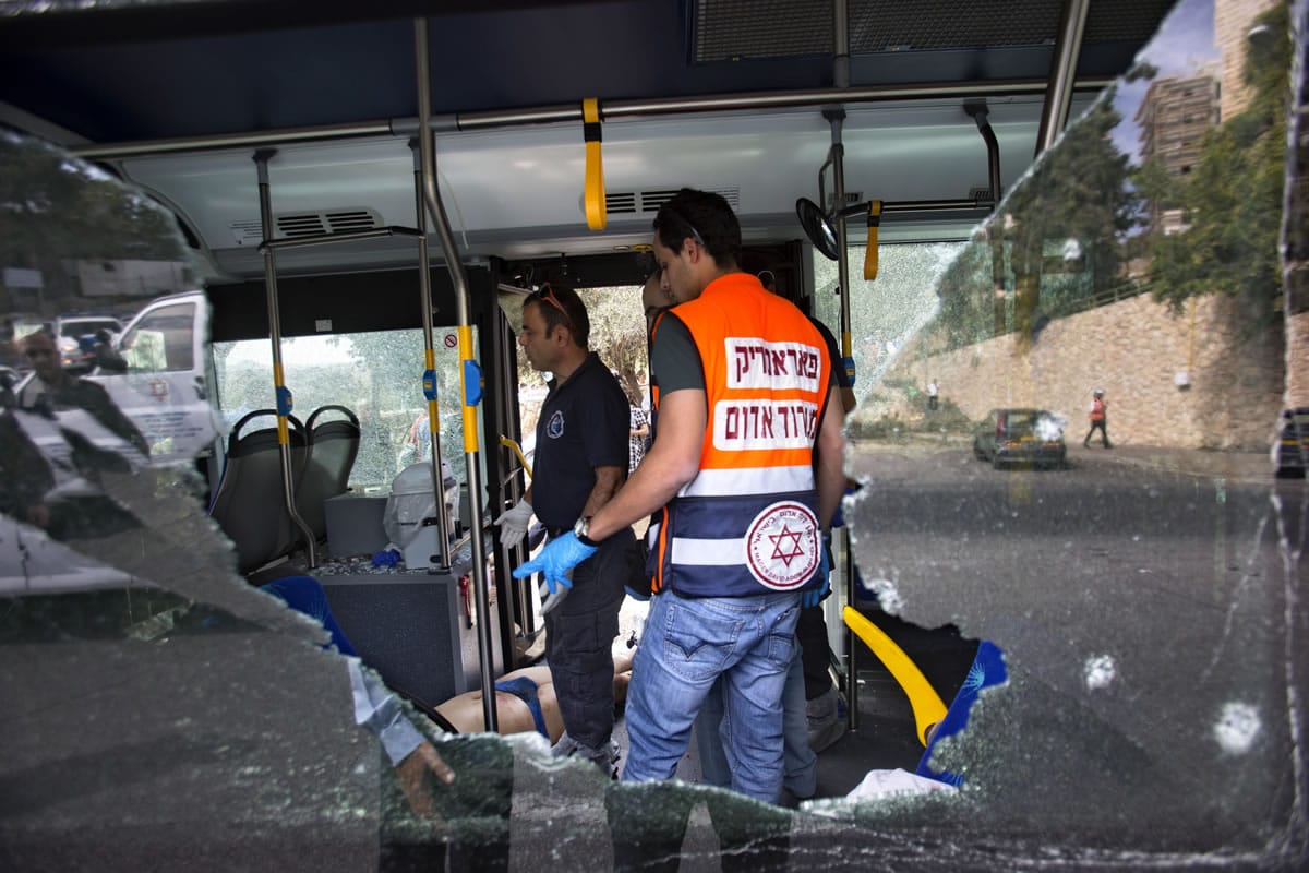 Israeli medics and police inspect the scene of a shooting attack on a bus Tuesday in Jerusalem.