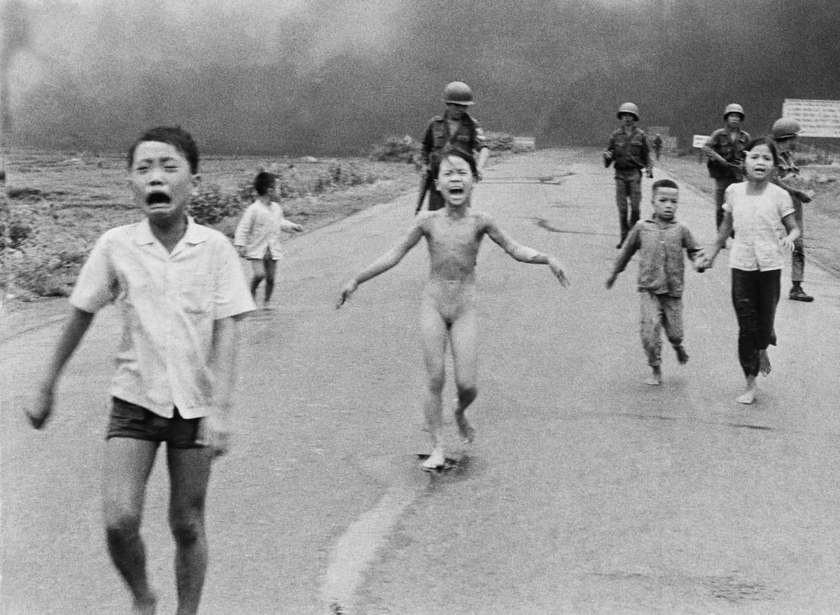 In this famed June 8, 1972, photo, 9-year-old Kim Phuc, center, runs with her brothers and cousins, followed by South Vietnamese forces, down Route 1 near Trang Bang after a South Vietnamese plane accidentally dropped its flaming napalm on its own troops and civilians. The terrified girl had ripped off her burning clothes while fleeing.