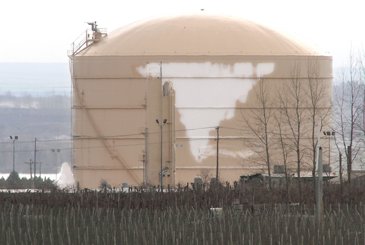 Liquefied natural gas vapors continue to leak Tuesday, leaving a frosty coating on the damaged storage tank at the Williams Northwest Pipeline facility near Plymouth.