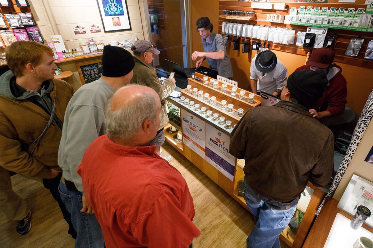 Employees of Amazon Organics, a pot dispensary in Eugene, Ore., help customers purchase recreational marijuana on Thursday. Oregon marijuana shops began selling marijuana Thursday for the first time to recreational users who are at least 21 years old, marking a big day for the budding pot industry.