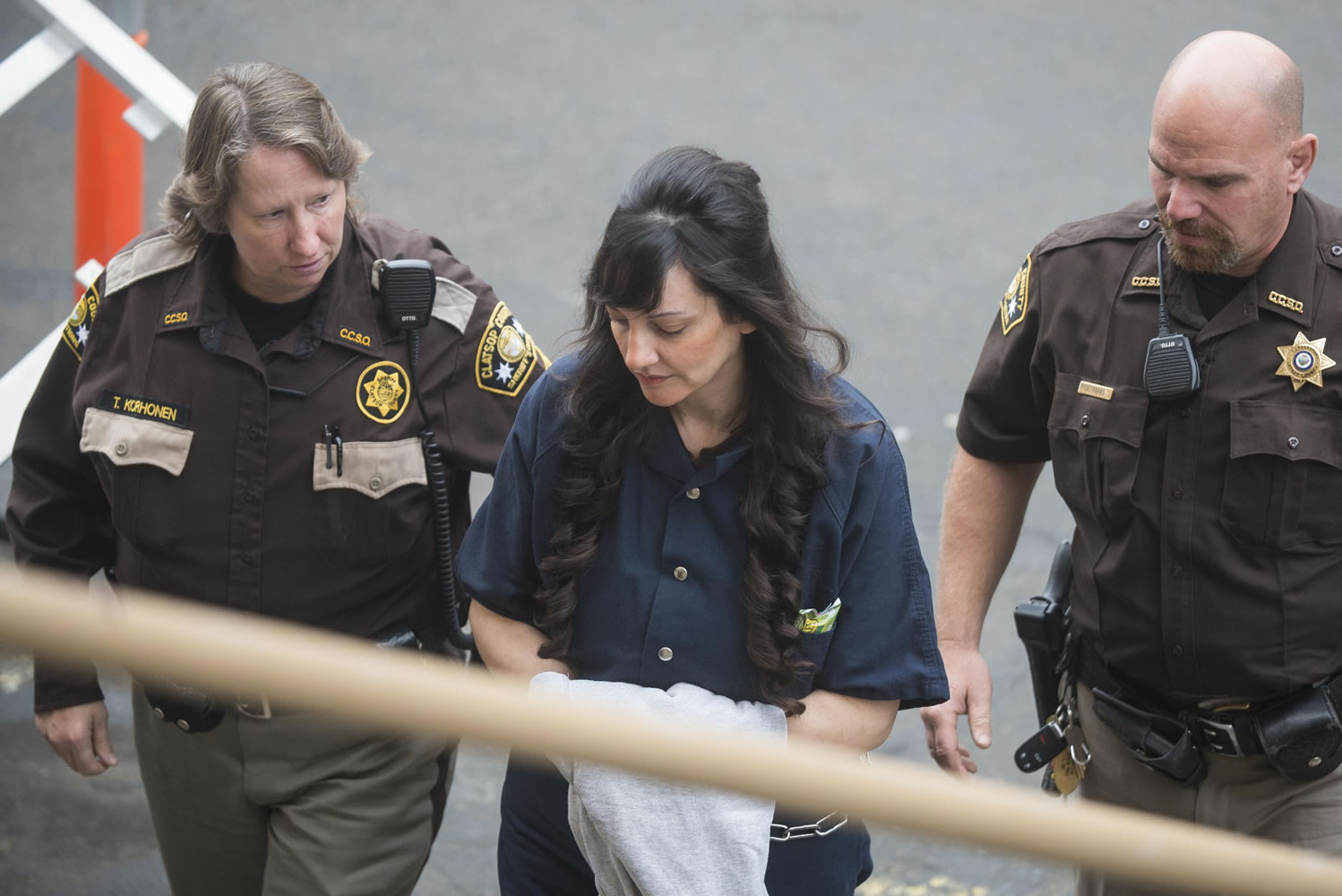 Jessica Smith, center, is led into the Clatsop County County Courthouse for a status hearing, Friday, in Astoria, Ore. Smith is charged with aggravated murder and attempted aggravated murder in the drowning death of her 2-year-old daughter and cutting the throat of her teenage daughter in Cannon Beach, Ore.