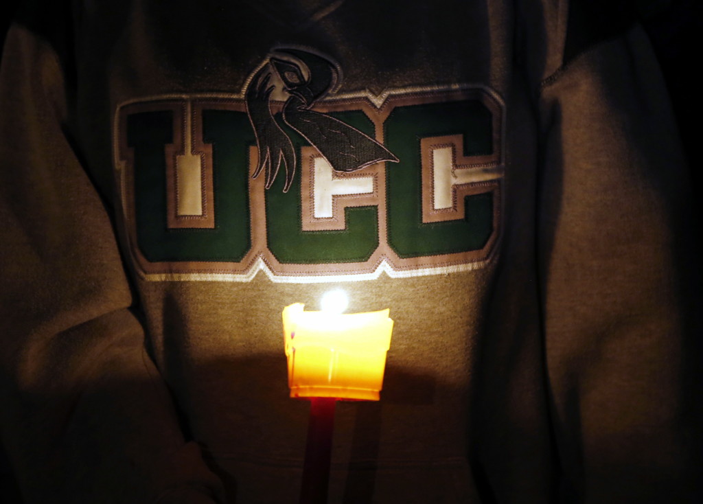 Diana Nicolay, a former employee of Umpqua Community College, wears a school sweatshirt during a candlelight vigil Thursday.