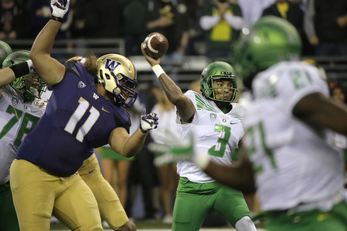 Oregon quarterback Vernon Adams Jr. (3) passes as Washington's Elijah Qualls (11) is blocked in the first half of an NCAA college football game, Saturday, Oct. 17, 2015, in Seattle. (AP Photo/Ted S.