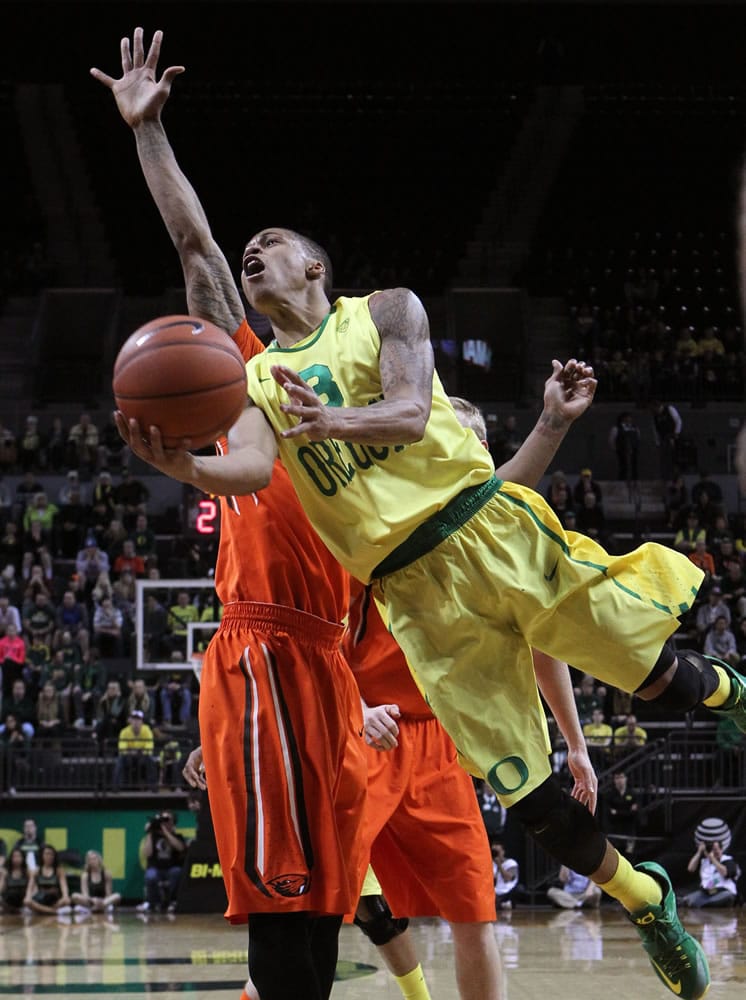 Oregon's Joseph Young shoots around Oregon State's Gary Payton II during the second half in Eugene, Ore., Saturday, Jan. 3, 2015.
