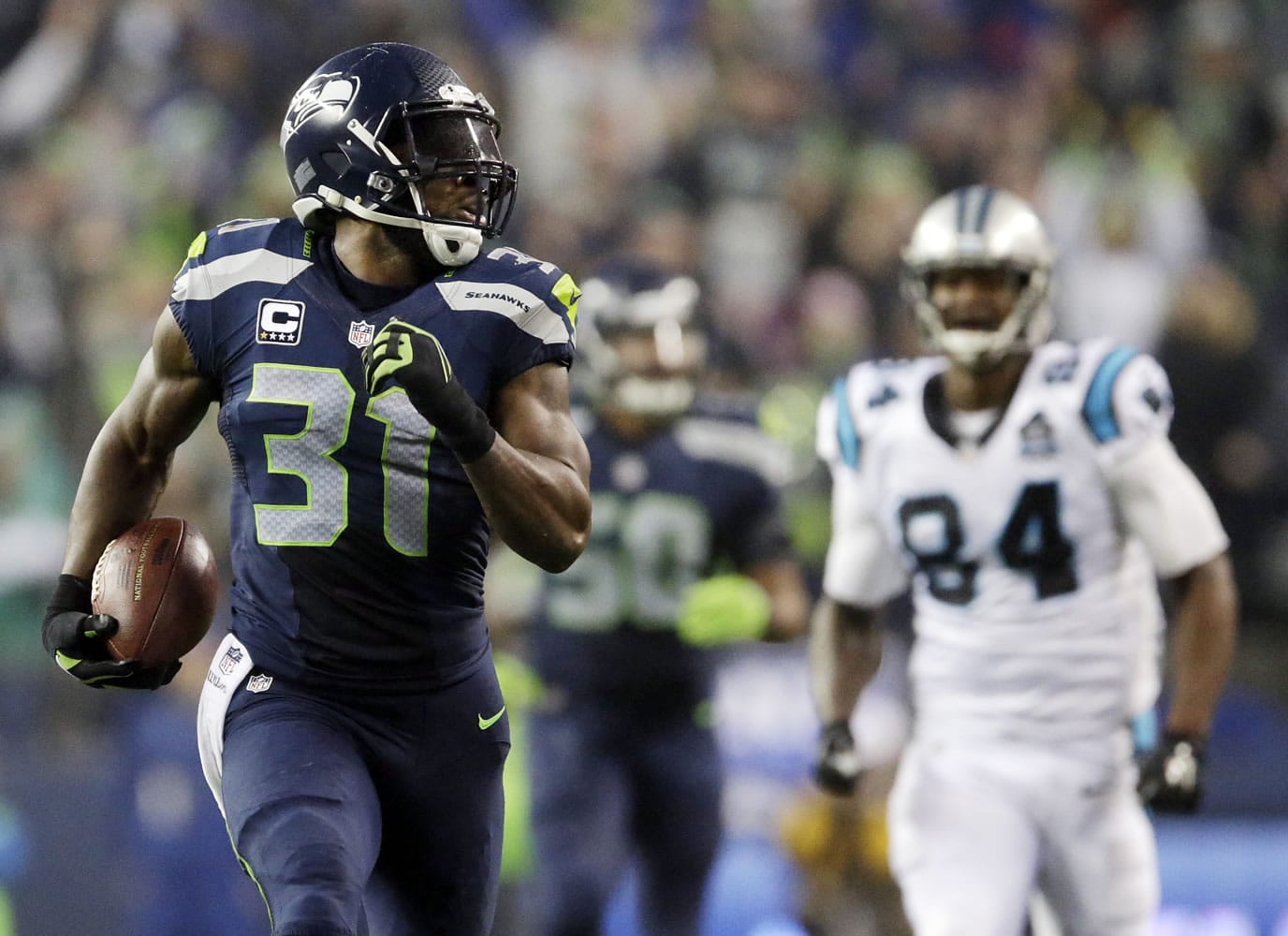 Seattle Seahawks strong safety Kam Chancellor (31) runs in front of Carolina Panthers tight end Ed Dickson (84) to score on a 90-yard interception return in the fourth quarter Saturday in the NFL divisional playoff game in Seattle, Saturday, Jan. 10, 2015.