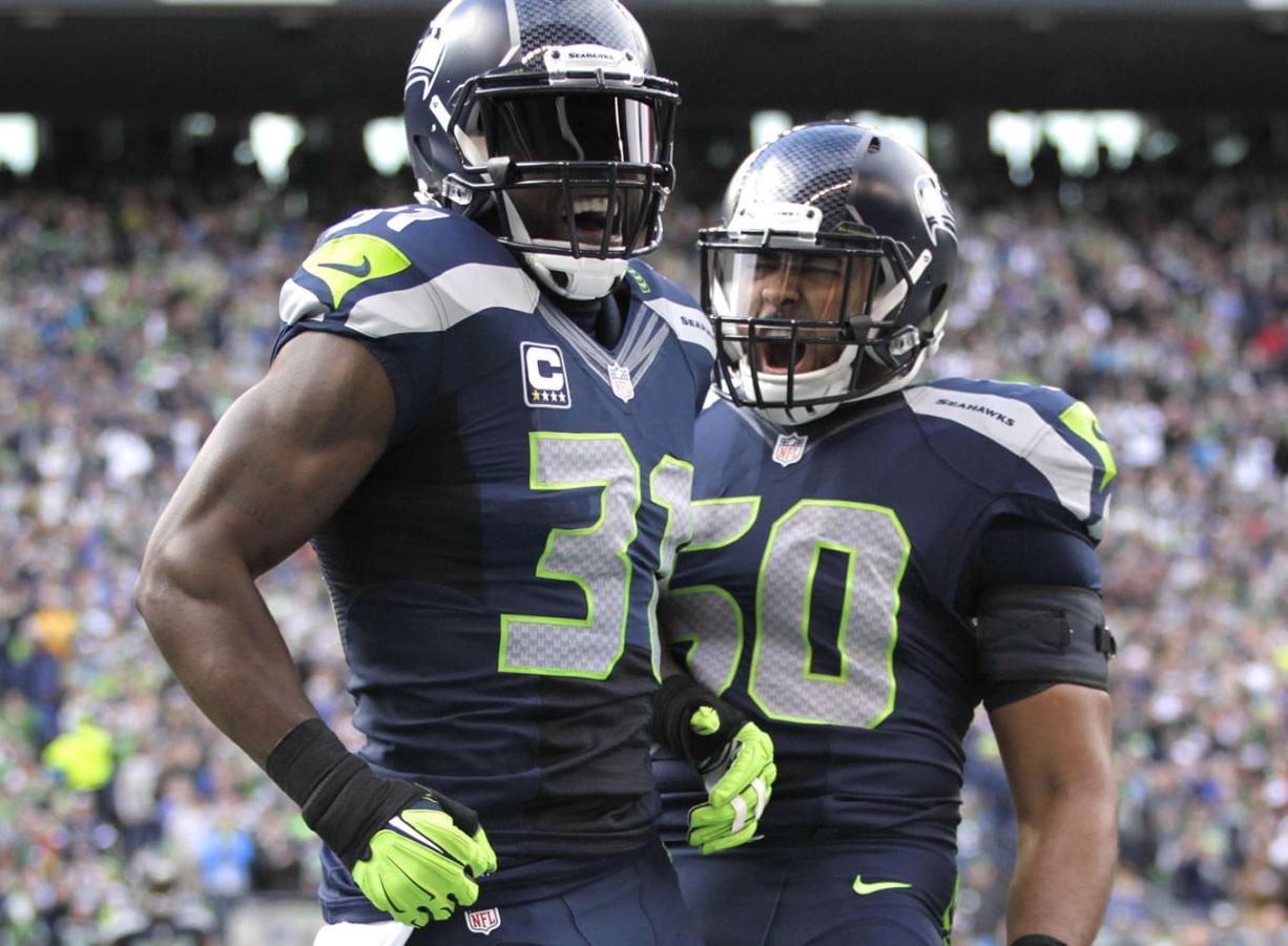 Seattle Seahawks' Kam Chancellor, left, and K.J. Wright, right, celebrate a play against the St. Louis Rams in the second half of an NFL football game, Sunday, Dec.