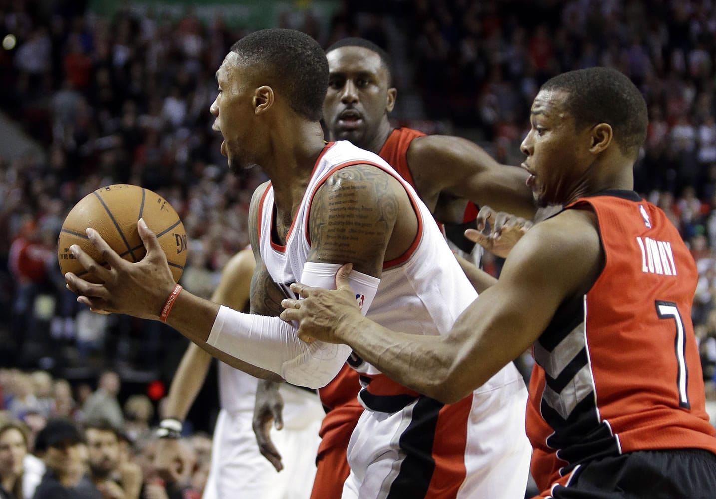 Portland Trail Blazers guard Damian Lillard, left, is fouled from behind by Toronto Raptors guard Kyle Lowry during overtime of an NBA basketball game in Portland, Ore., Tuesday, Dec. 30, 2014. Lillard led the Trail Blazers in scoring with 26 ponts as they beat the Raptors in overtime 102-97.