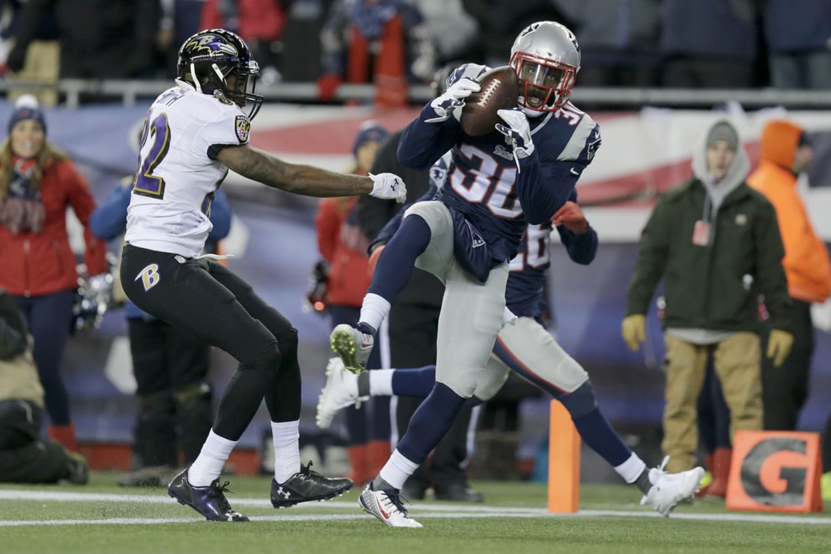New England Patriots strong safety Duron Harmon (30) intercepts a pass by Baltimore Ravens quarterback Joe Flacco in front of Baltimore wide receiver Torrey Smith (82) in the closing minutes of the divisional playoff game Saturday, Jan. 10, 2015, in Foxborough, Mass.