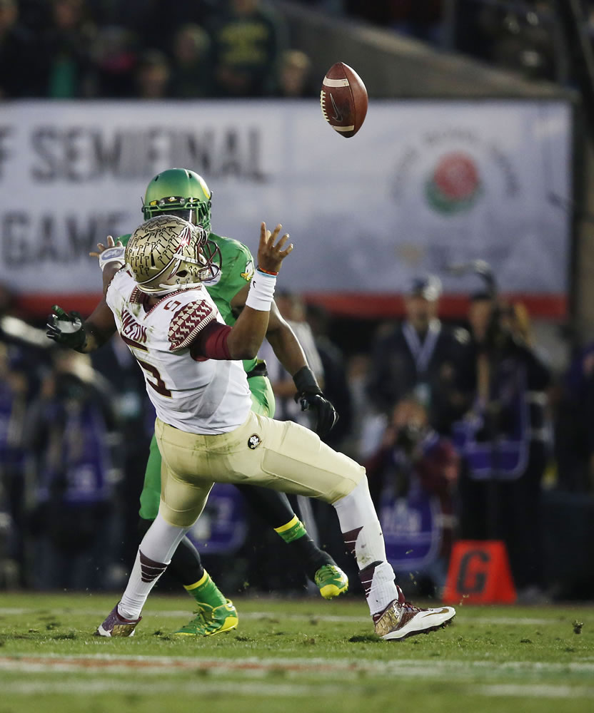 Oregon linebacker Tony Washington (91) forces a fumble by Florida State quarterback Jameis Winston (5), and then returned the ball for a touchdown in the Rose Bowl, Thursday, Jan. 1, 2015 in Pasadena, Calif.