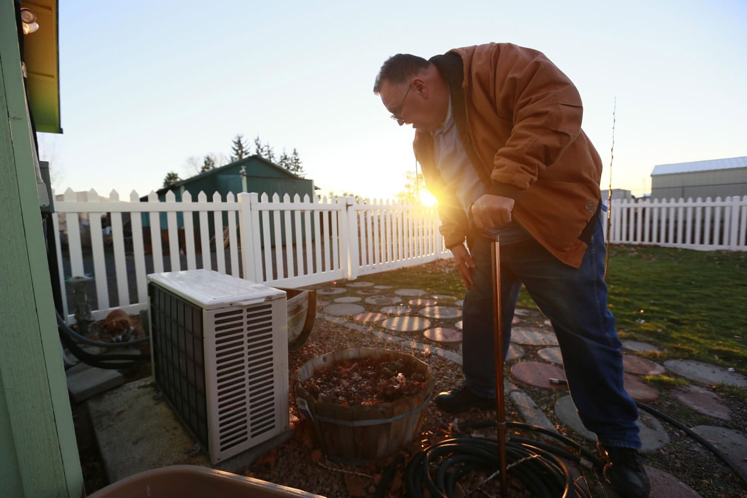 Harry Carman talks Wednesday about damage to his planters and around his heat pump from rabbits' digging at his Culver, Ore., home.