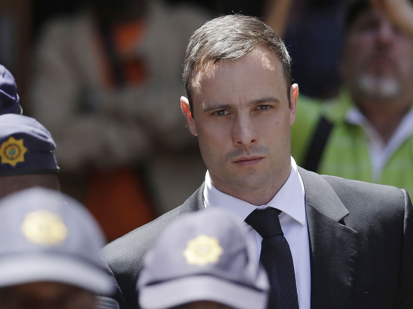 Oscar Pistorius is escorted by police officers as he leaves the high court in Pretoria, South Africa., on Oct. 17. Pistorius is  to be released from jail Tuesday under house arrest.