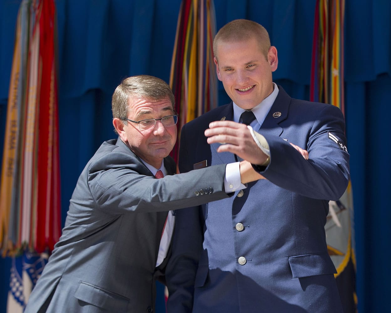 Defense Secretary Ash Carter, left, raises the injured left arm of Airman 1st Class Spencer Stone Sept. 17 before Stone received the Airman&#039;s Medal and Purple Heart medal, during a ceremony at the Pentagon in Washington. An Air Force spokesman says Stone, who helped subdue an attacker on a Paris-bound train in August, is in stable condition after being stabbed in California.