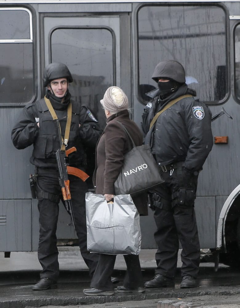 A woman speaks to riot police officers at the Hotel Dnipro in Kiev, Ukraine, on Tuesday.