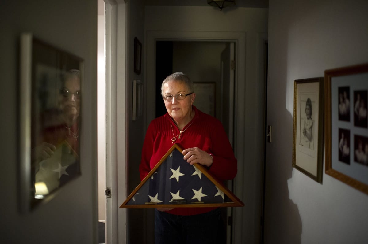Barbara Belton holds a flag Tuesday memorializing her father-in-law Delbert &quot;Shorty&quot; Belton at her home in Spokane. On Wednesday, a teenage suspect pleaded guilty in the 2013 beating death of the 88-year-old veteran.