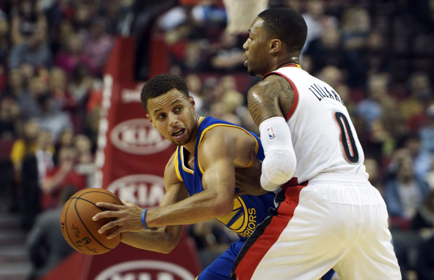 Golden State Warriors guard Stephen Curry, left, looks to pass the ball as Portland Trail Blazers guard Damian Lillard (0) defends during the first quarter of an NBA basketball game in Portland, Ore., Thursday, Oct. 8, 2015.
