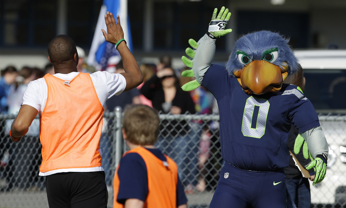 Blitz, the Seattle Seahawks NFL football mascot, gives a high five Monday at a community gathering in Darrington.