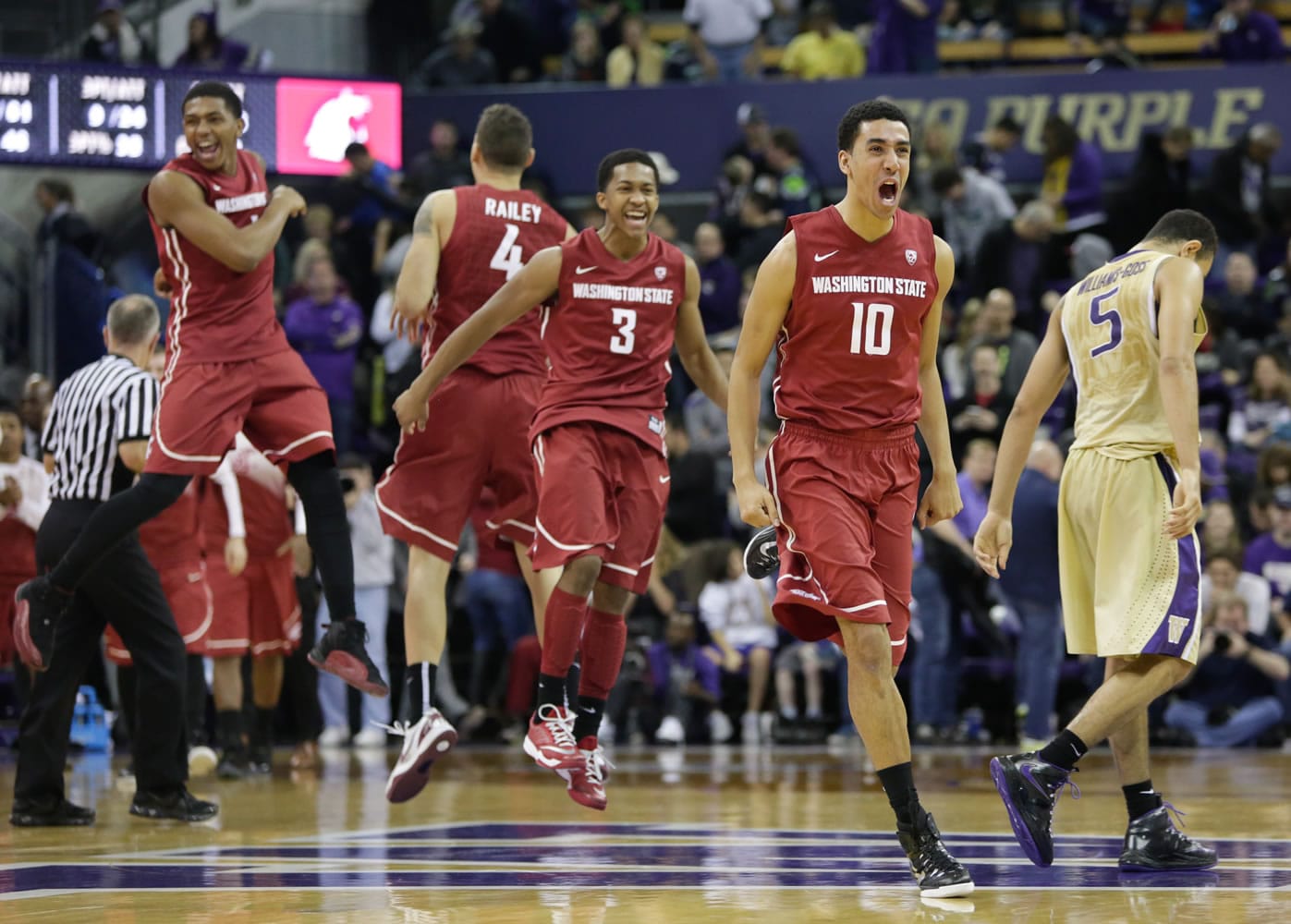 Washington State players Dexter Kernich-Drew (10) Ny Redding (3), Jordan Railey (4) and Jackie Davis, left, celebrate as Washington's Nigel Williams-Goss (5) walks off the court after the Cougars beat the Huskies 80-77 Saturday at Seattle.