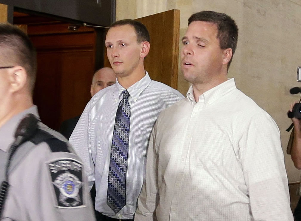Former Milwaukee police officers Graham Kunisch, right,  and Bryan Norberg, who were shot and seriously wounded by a gun purchased at a Wisconsin gun store, leave court Tuesday in Milwaukee after jurors ordered the gun store to pay nearly $6 million in damages.
