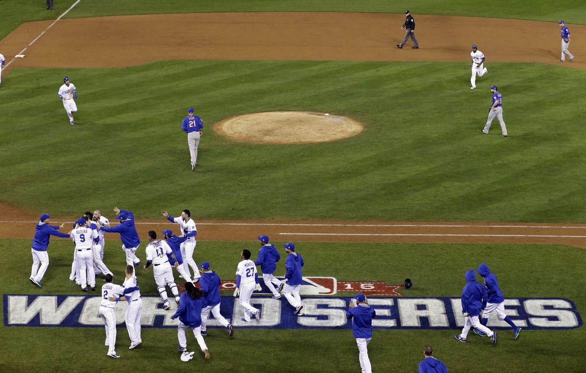 Kansas City Royals players celebrate Eric Hosmer&#039;s game wining sacrifice fly ball during the 14th inning of Game 1 of the Major League Baseball World Series against the New York Mets Wednesday, Oct. 28, 2015, in Kansas City, Mo. (AP Photo/David J.