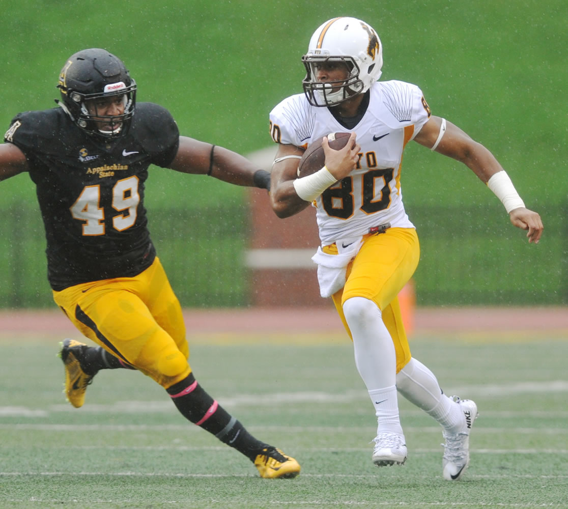 Wyoming wide receiver James Price, a graduate of Camas High School, gets past Appalachian State defensive lineman Ronald Blair (49) during the first half Saturday.