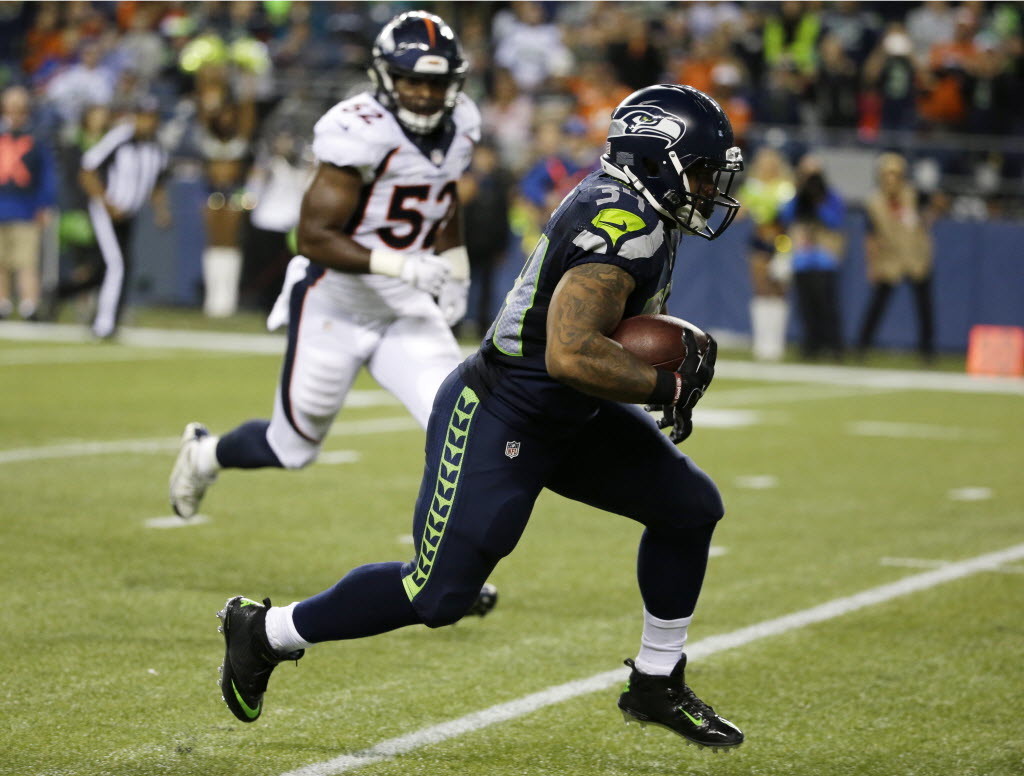 Seattle Seahawks running back Thomas Rawls, right, runs past Denver Broncos outside linebacker Corey Nelson, left, for a touchdown after catching a pass during the second half of a preseason NFL football game, Friday, Aug. 14, 2015, in Seattle.