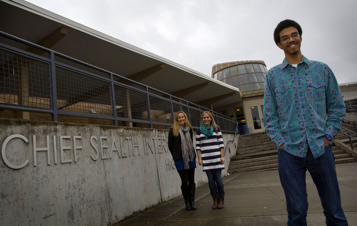 Franky Price, 16, stands in front of Chief Sealth International High School in Seattle. In the background are social workers Kim Peltola, left, and Carrie Syvertsen.