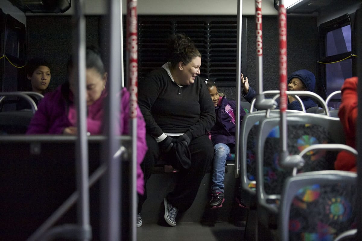 Photos by Steven Lane/The Columbian
Jessica Richey, center, and her children, Isaac, 12, left, and 7-year-old twins Saakkaaya and Ezekiel ride a C-Tran bus to school. The family has been homeless since the beginning of the school year, and the daily commute to school often takes more than an hour.