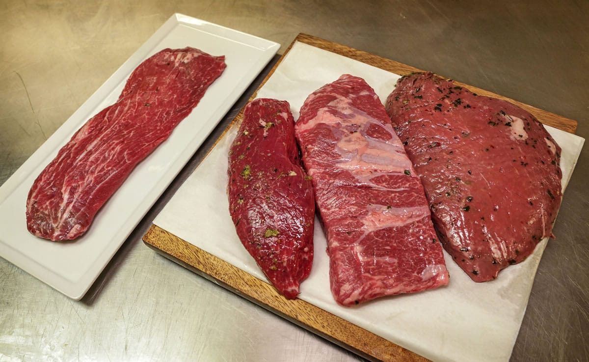 Flatiron/Backyard, from left, Teres Major, Boneless Chuck Flat and Top Sirloin Culotte cuts are readied on the kitchen table Oct.