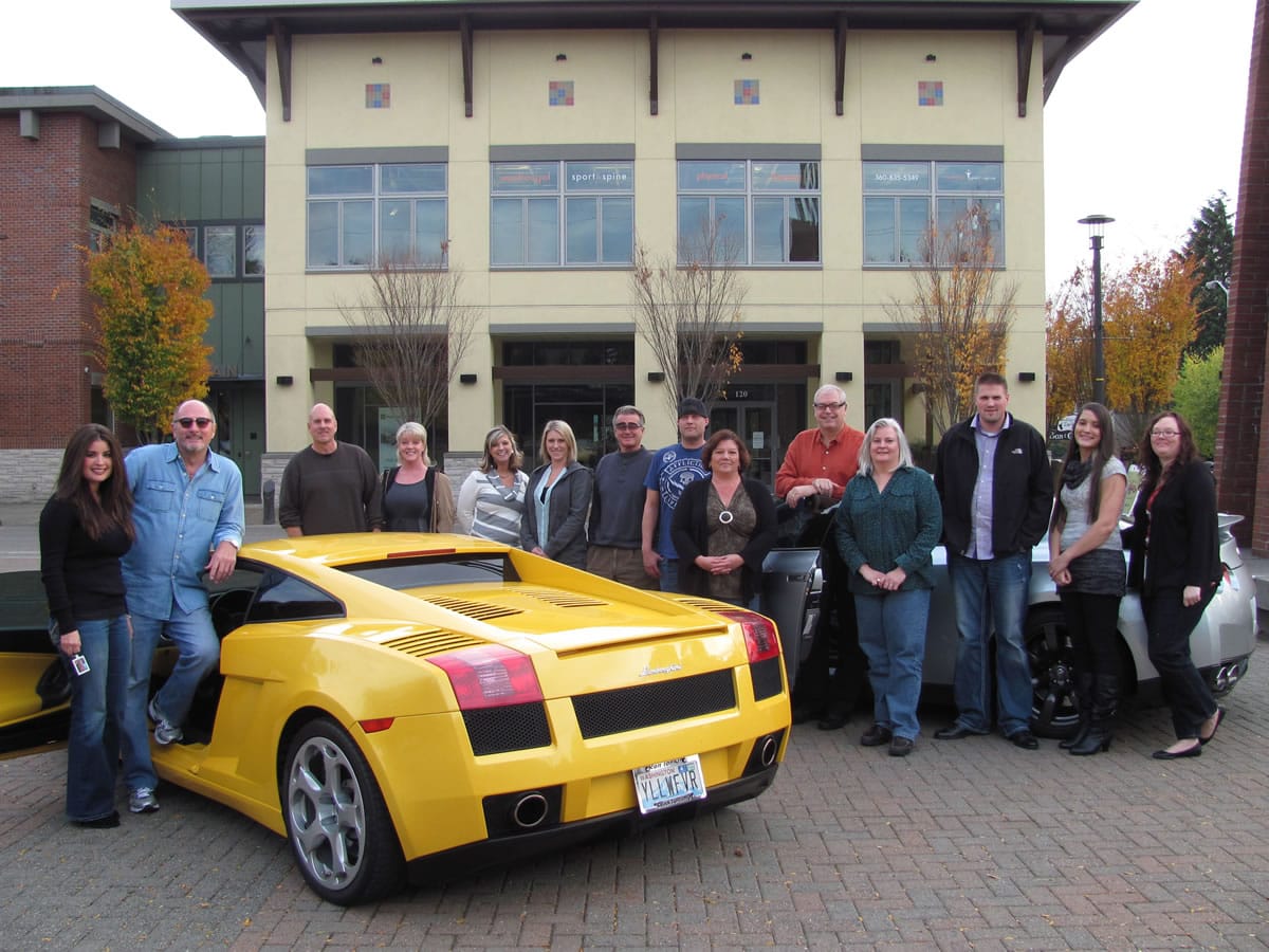 Terry Williams (second from left), president, chief executive officer and founder of Transport Holding Co., Inc., stands with his fiance Felicia Bond and staff members, by his 2004 Lamborghini, in Reflection Plaza. Bond is the Texas regional director for Red Carpet Auto Transport, Inc., one of the six auto shipping brokerages that Transport Holding owns.