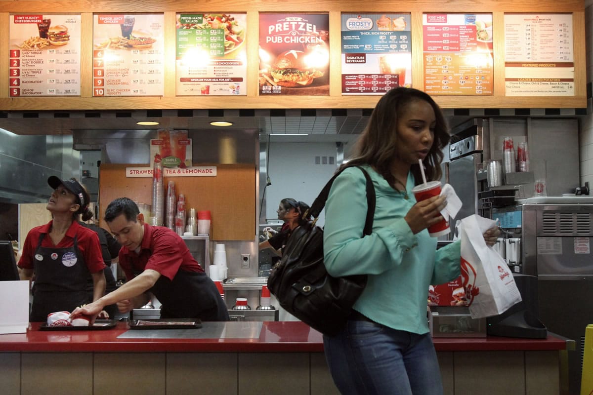 Dalia Aguilera, left, and Alejandro Velasquez prepare orders for customers at Wendy's in Burbank, Calif.,  in September. In January, Wendy's 99-cent bargain menu transformed into Right Price Right Size and includes items costing as much as $2.