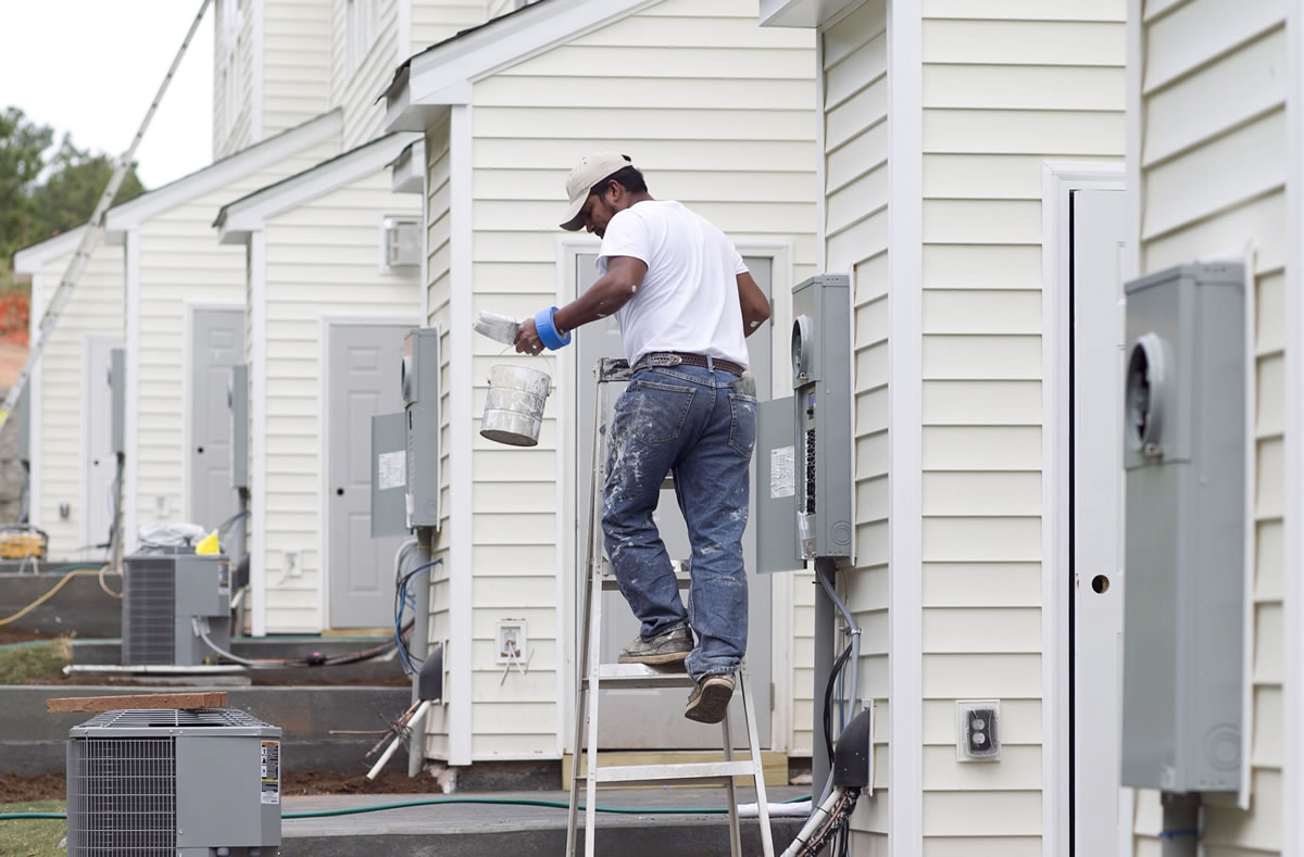 Painter Carlos Alvaro touches up the exterior of a townhome in Morrisville, N.C.